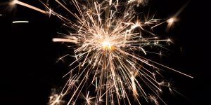 Sparkler emitting bright sparks against a dark background, symbolizing celebration and reflection, related to mental health and personal growth.