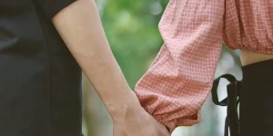 Couple holding hands in a supportive gesture, symbolizing connection and emotional support related to anxiety management and therapy.