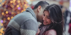 Couple embracing and smiling together in a festive setting, highlighting connection and intimacy, relevant to couples therapy insights and relationship improvement.