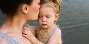 Mother comforting child, illustrating emotional connection and support in trauma recovery context.